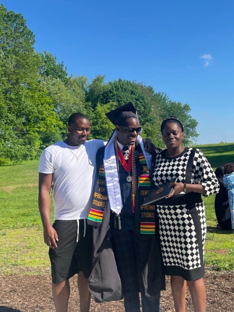 A photo of Saquan Taylor at graduation with his mom and brother